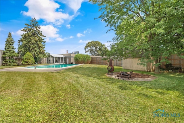 view of yard with a fire pit and a fenced in pool