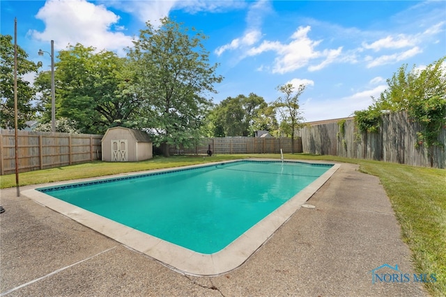 view of pool with a shed and a lawn