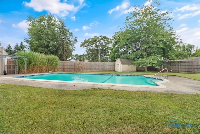 view of swimming pool with a storage unit and a yard