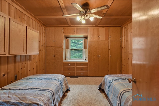 carpeted bedroom with ceiling fan, wooden ceiling, and wood walls