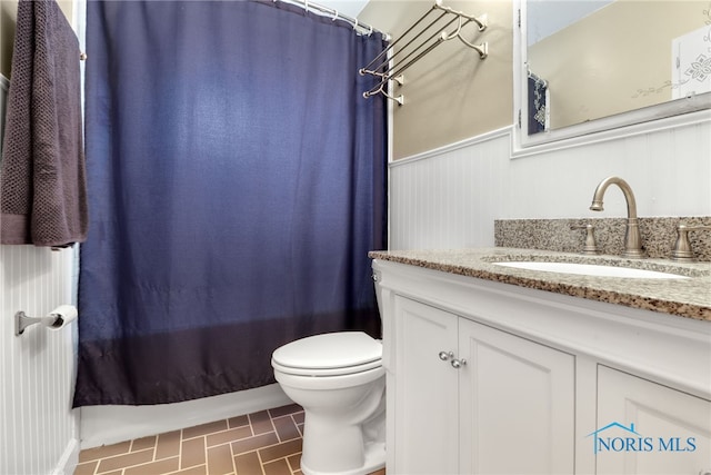 full bathroom with tile patterned floors, vanity, shower / tub combo with curtain, toilet, and wood walls