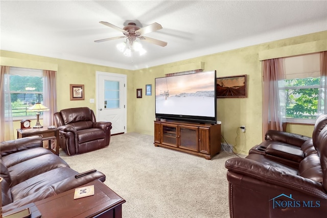 carpeted living room featuring ceiling fan and a wealth of natural light