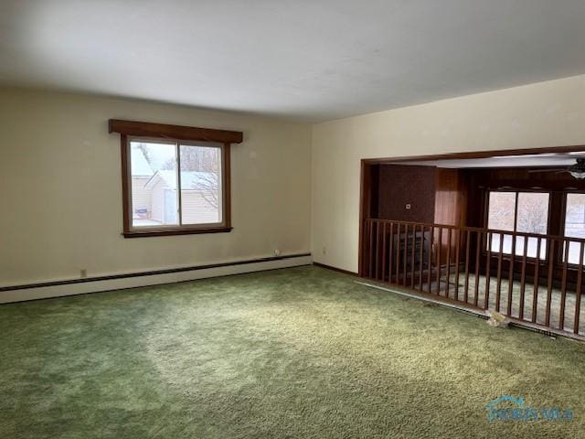 carpeted spare room featuring baseboard heating