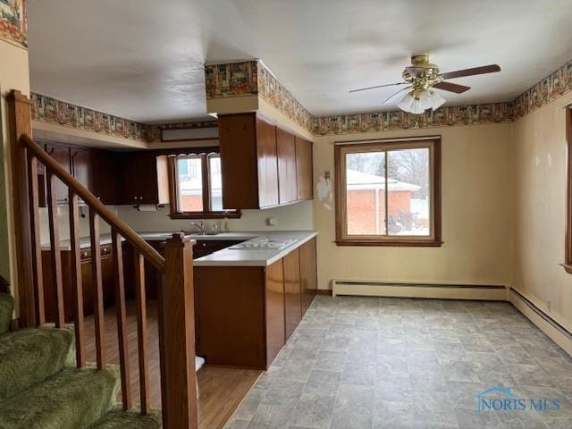 kitchen featuring a wealth of natural light, light hardwood / wood-style flooring, ceiling fan, and a baseboard radiator