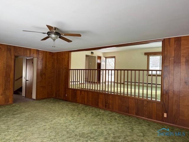 spare room featuring carpet flooring, ceiling fan, a healthy amount of sunlight, and a baseboard heating unit