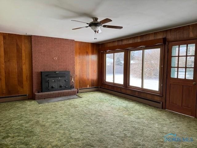 unfurnished living room featuring light carpet, baseboard heating, a wood stove, and ceiling fan