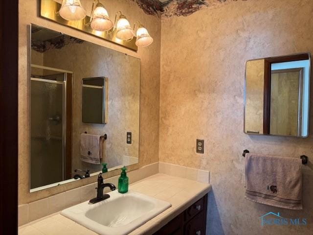 bathroom featuring vanity and a shower with shower door