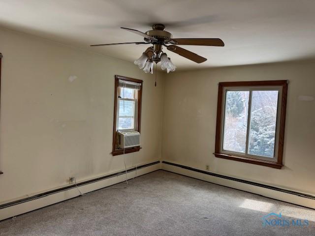 carpeted spare room with cooling unit, a wealth of natural light, a baseboard heating unit, and ceiling fan