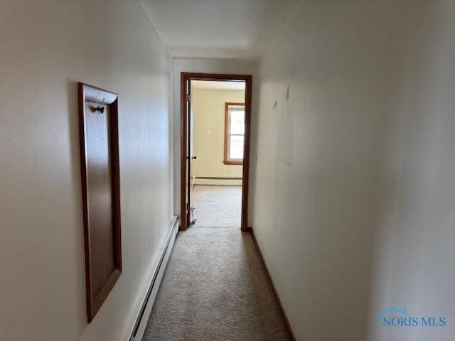 hallway featuring light carpet and a baseboard heating unit