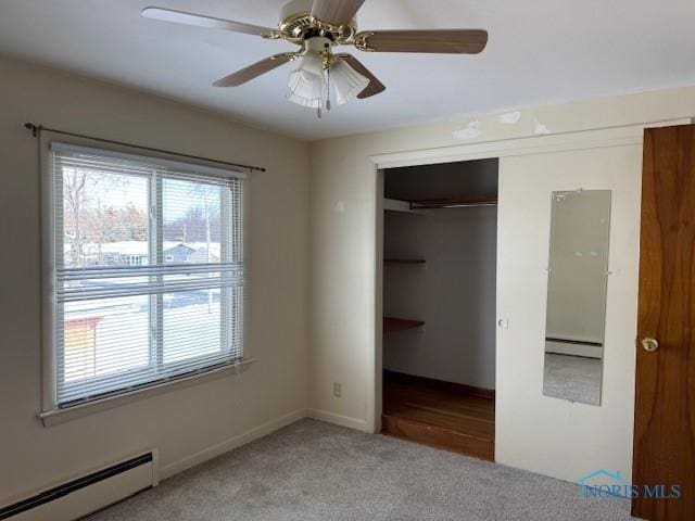 unfurnished bedroom with carpet, a closet, baseboard heating, and ceiling fan