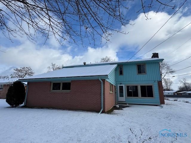 view of snow covered rear of property