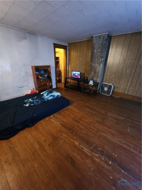 unfurnished bedroom featuring dark hardwood / wood-style floors and wooden walls