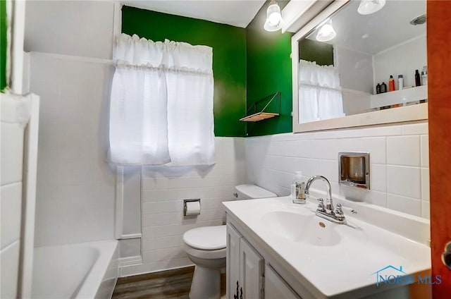 bathroom featuring vanity, hardwood / wood-style flooring, toilet, and tile walls