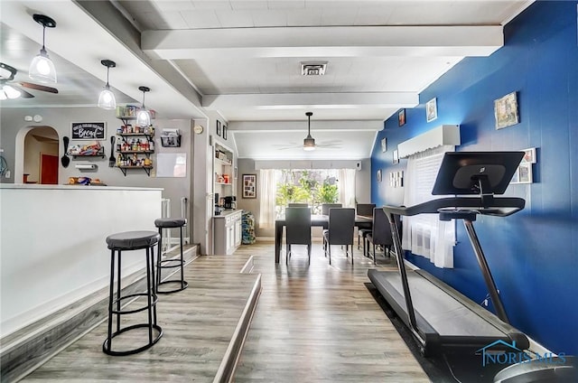 workout room with ceiling fan and light wood-type flooring