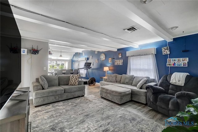 living room featuring beamed ceiling and hardwood / wood-style flooring