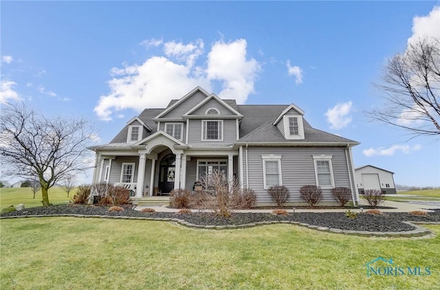 view of front of home with a front lawn, an outdoor structure, and a garage