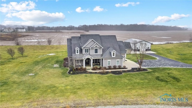 view of front of house featuring a front lawn, a rural view, and a porch