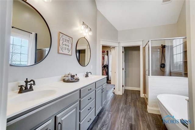 bathroom featuring wood-type flooring, vanity, lofted ceiling, and independent shower and bath