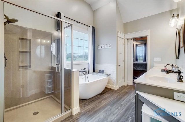 bathroom with hardwood / wood-style flooring, vanity, lofted ceiling, and shower with separate bathtub