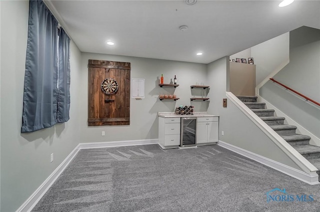 bar with white cabinets, dark colored carpet, and beverage cooler