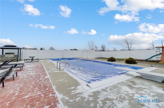 view of pool with a diving board and a patio