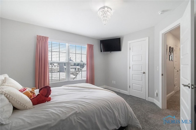 bedroom with a notable chandelier and carpet floors