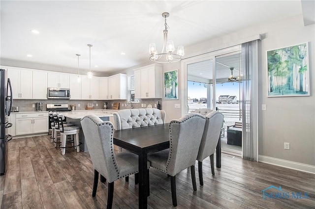 dining area with dark wood-type flooring and a notable chandelier