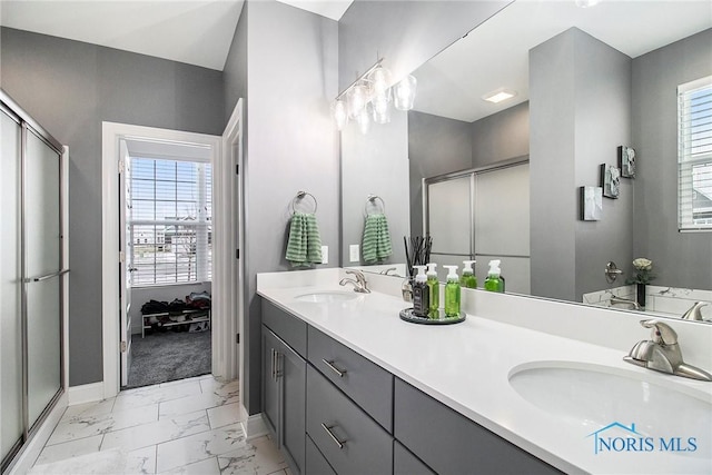 bathroom featuring vanity, a shower with door, and a healthy amount of sunlight