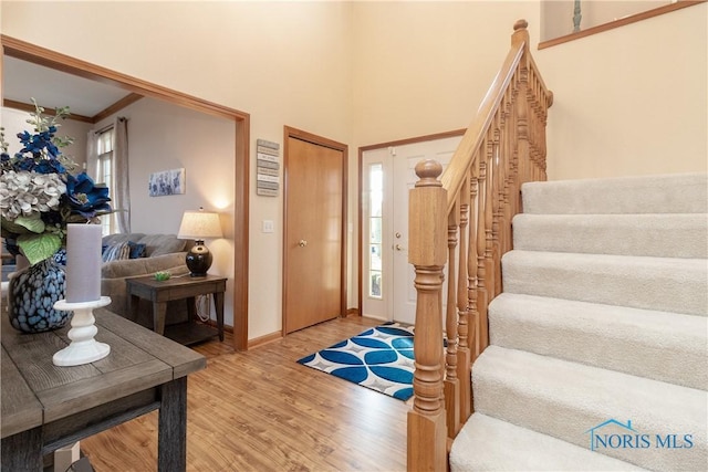 entryway featuring wood-type flooring and ornamental molding