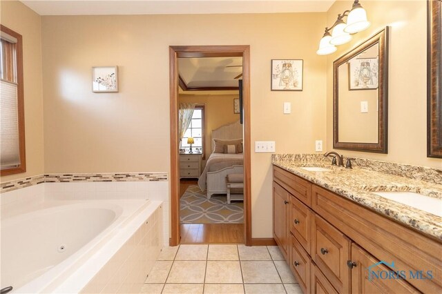 bathroom featuring tile patterned floors, tiled tub, and vanity