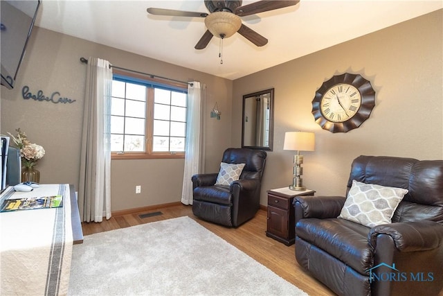 sitting room with light hardwood / wood-style floors and ceiling fan