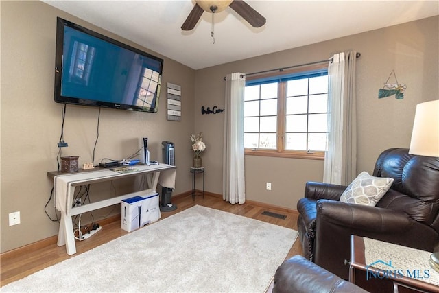 living room with wood-type flooring and ceiling fan