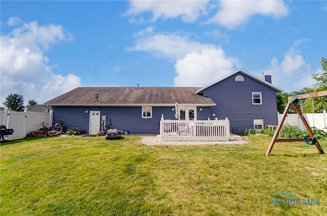 back of house with a playground and a lawn