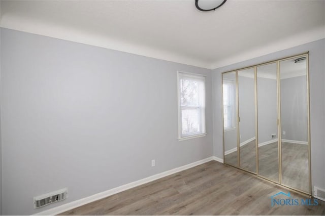 unfurnished bedroom featuring hardwood / wood-style flooring and a closet