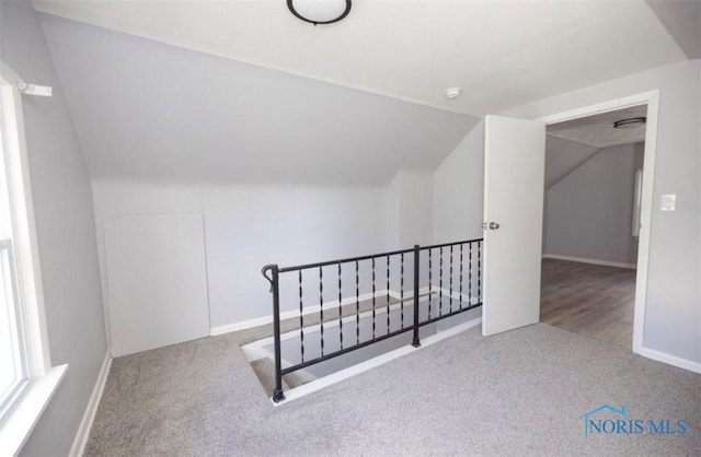 bonus room with light colored carpet and lofted ceiling