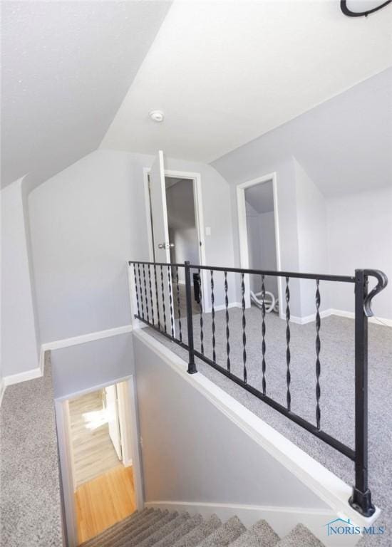 staircase with carpet and vaulted ceiling