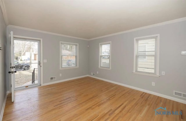 empty room with light wood-type flooring and crown molding