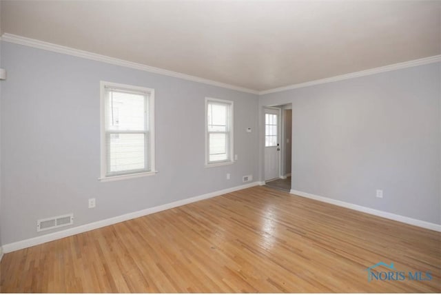 spare room featuring light hardwood / wood-style floors and crown molding