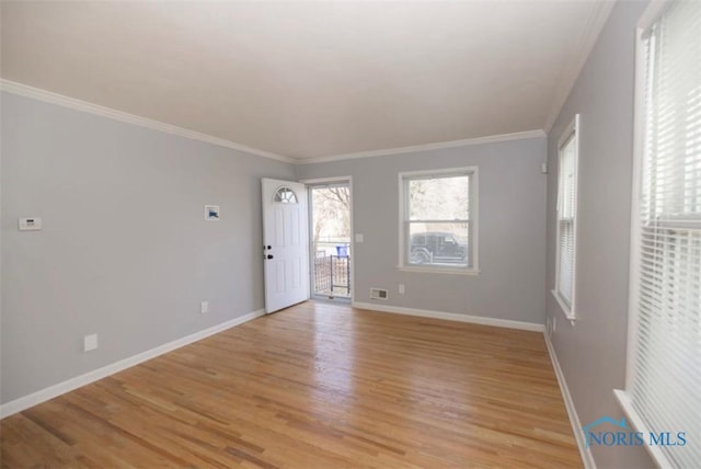 unfurnished room featuring ornamental molding and light hardwood / wood-style flooring