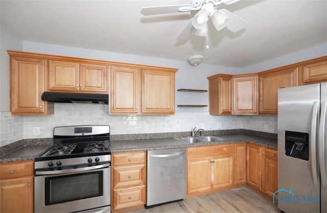 kitchen featuring appliances with stainless steel finishes, light wood-type flooring, tasteful backsplash, ceiling fan, and sink