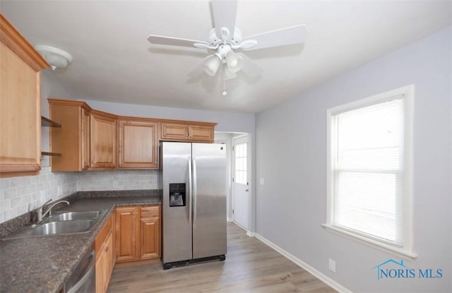 kitchen with ceiling fan, sink, light hardwood / wood-style flooring, decorative backsplash, and appliances with stainless steel finishes