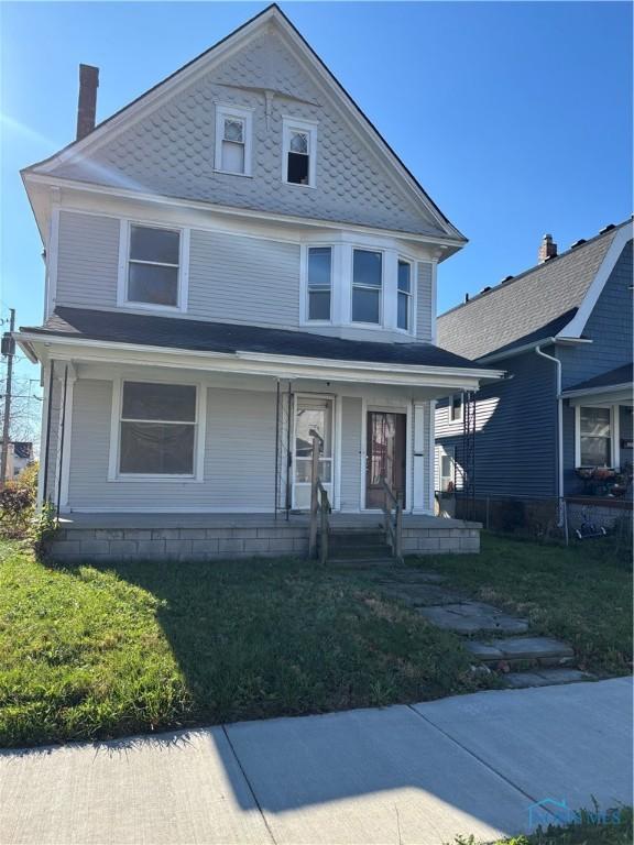 view of front of property with a porch and a front yard