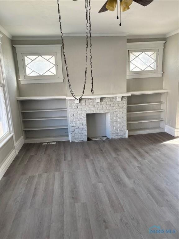 unfurnished living room featuring wood-type flooring, ceiling fan, and crown molding