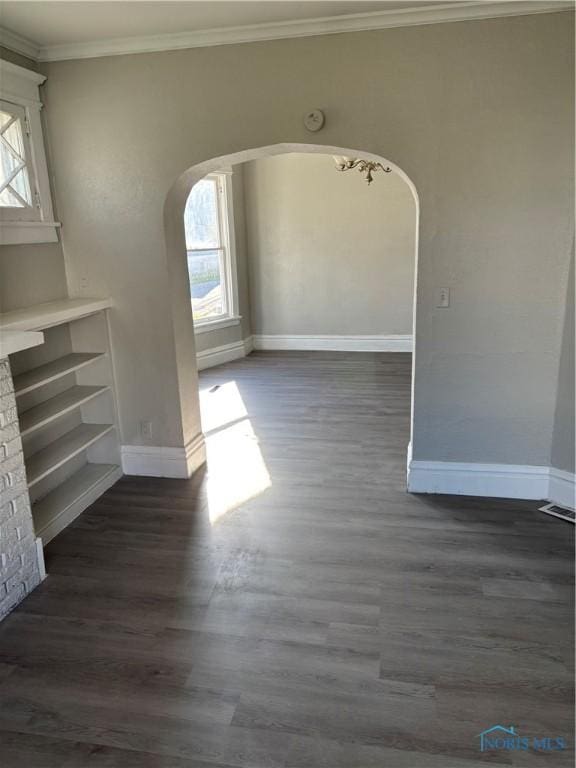 unfurnished living room featuring plenty of natural light, dark hardwood / wood-style flooring, and crown molding