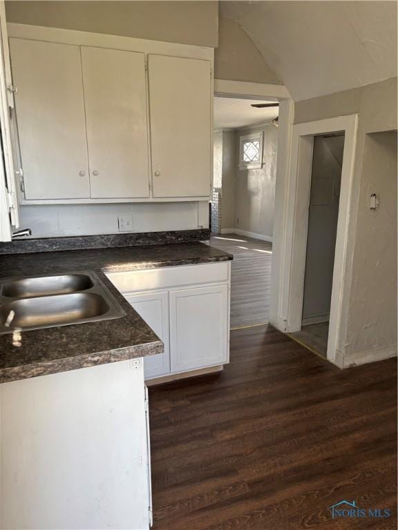 kitchen featuring white cabinetry, dark wood-type flooring, and sink