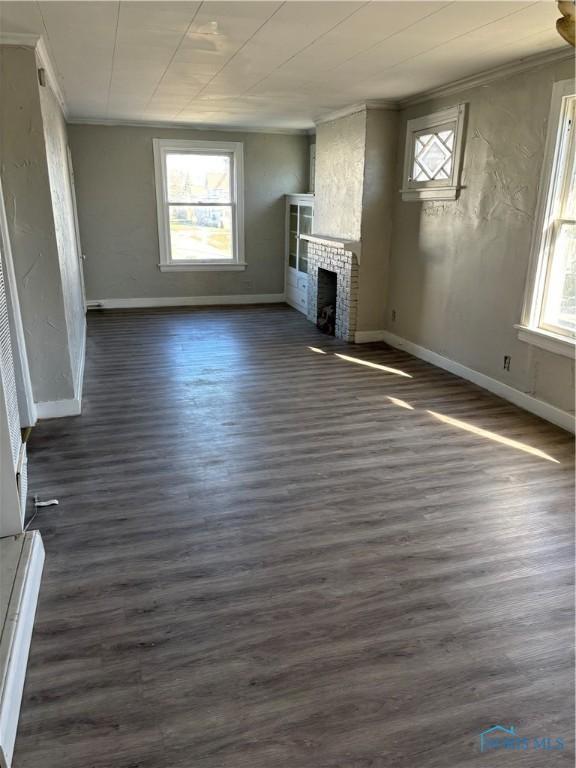 unfurnished living room with crown molding, a fireplace, and dark hardwood / wood-style floors