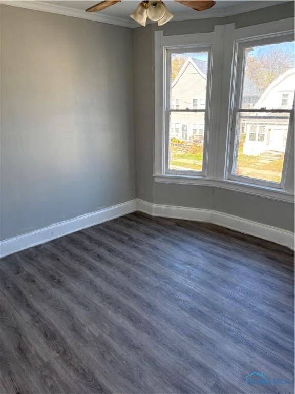 unfurnished room with dark hardwood / wood-style floors, ceiling fan, and ornamental molding