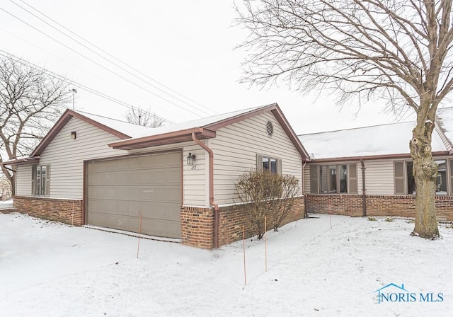 view of snowy exterior featuring a garage