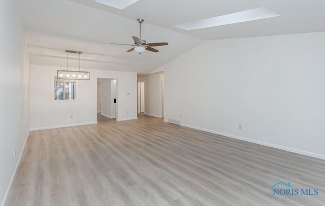 spare room featuring light hardwood / wood-style floors, lofted ceiling with skylight, and ceiling fan