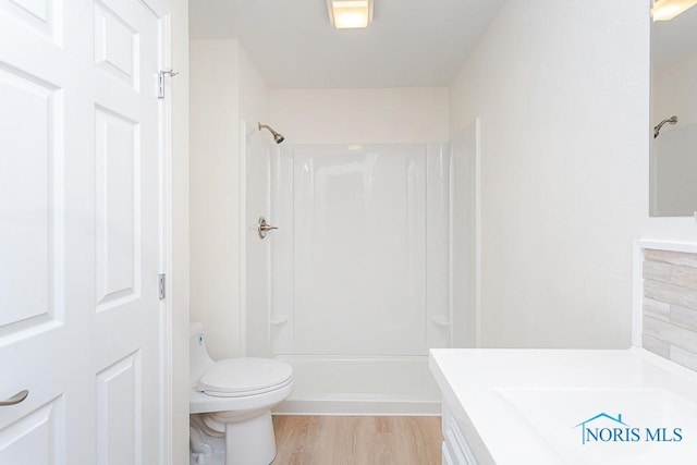 bathroom with hardwood / wood-style floors, vanity, toilet, and walk in shower